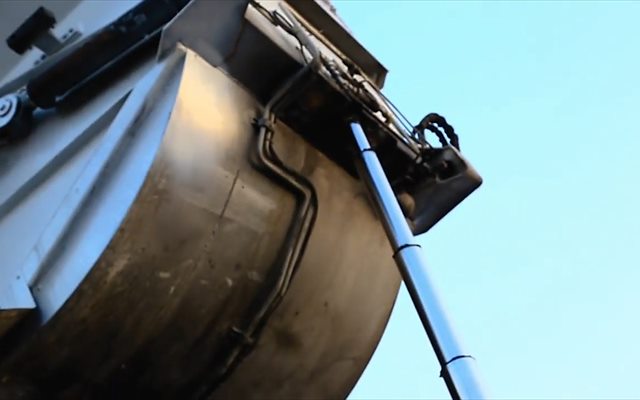 Контейнер разгружается в кузов мусоровоза